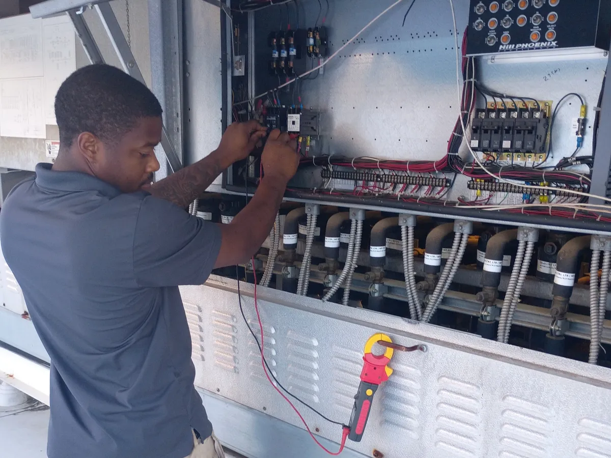 Commercial refrigeration rack repair - Decatur Solution Works technician testing a rack system control panel